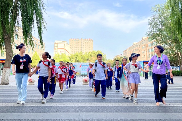 01 臨澤縣城關(guān)小學(xué)“紅燭先鋒”護學(xué)崗教師護送學(xué)生放學(xué)。謝靜 攝.jpg