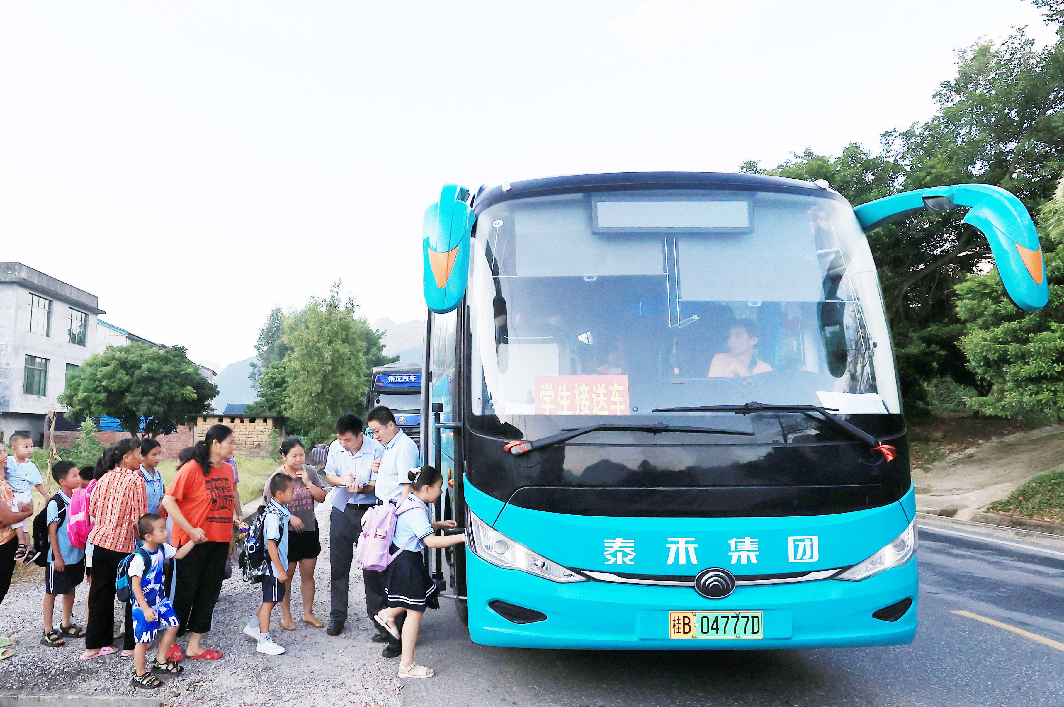 圖2：9月2日早晨，在廣西柳州市融安縣浮石鎮(zhèn)諫村村，工作人員在核對乘車人員名單，準(zhǔn)備送學(xué)生去學(xué)校讀書。（譚凱興 攝）.JPG