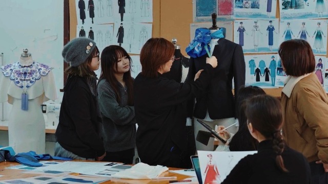 東華大學服裝與藝術設計學院師生團隊在討論結構細節(jié)。學校供圖