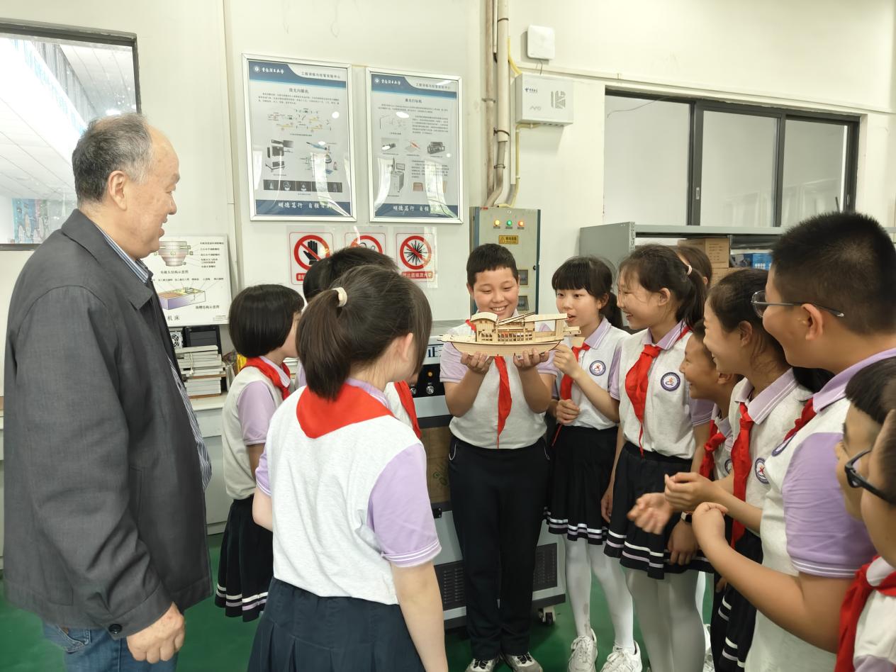 指導小學生用激光雕刻技術制作“紅船”